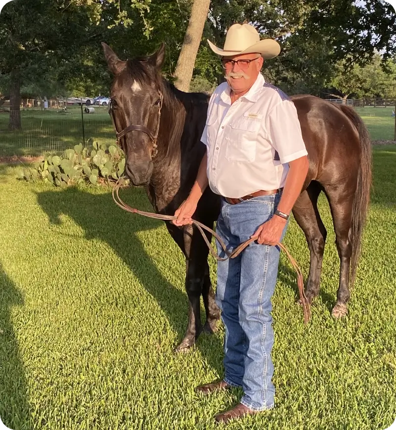 Man in cowboy hat with dark horse.