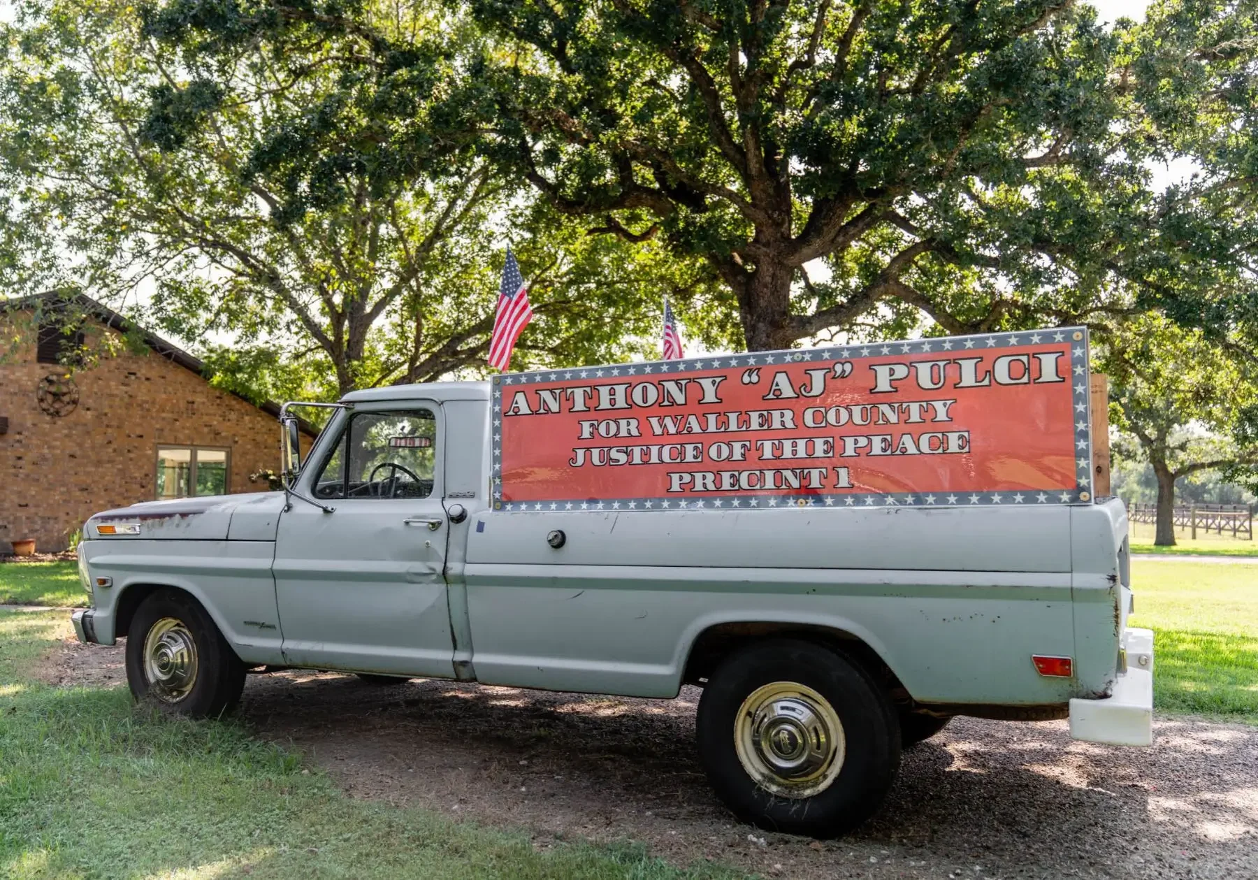 Light-blue vintage pickup truck with campaign sign